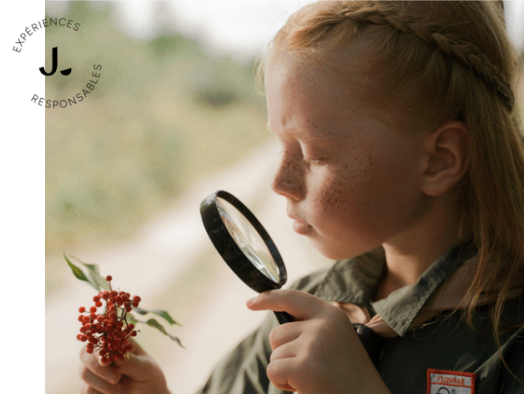Enfant qui observe avec une loupe dans un univers immersif proposé par l'agence Les Jeannettes